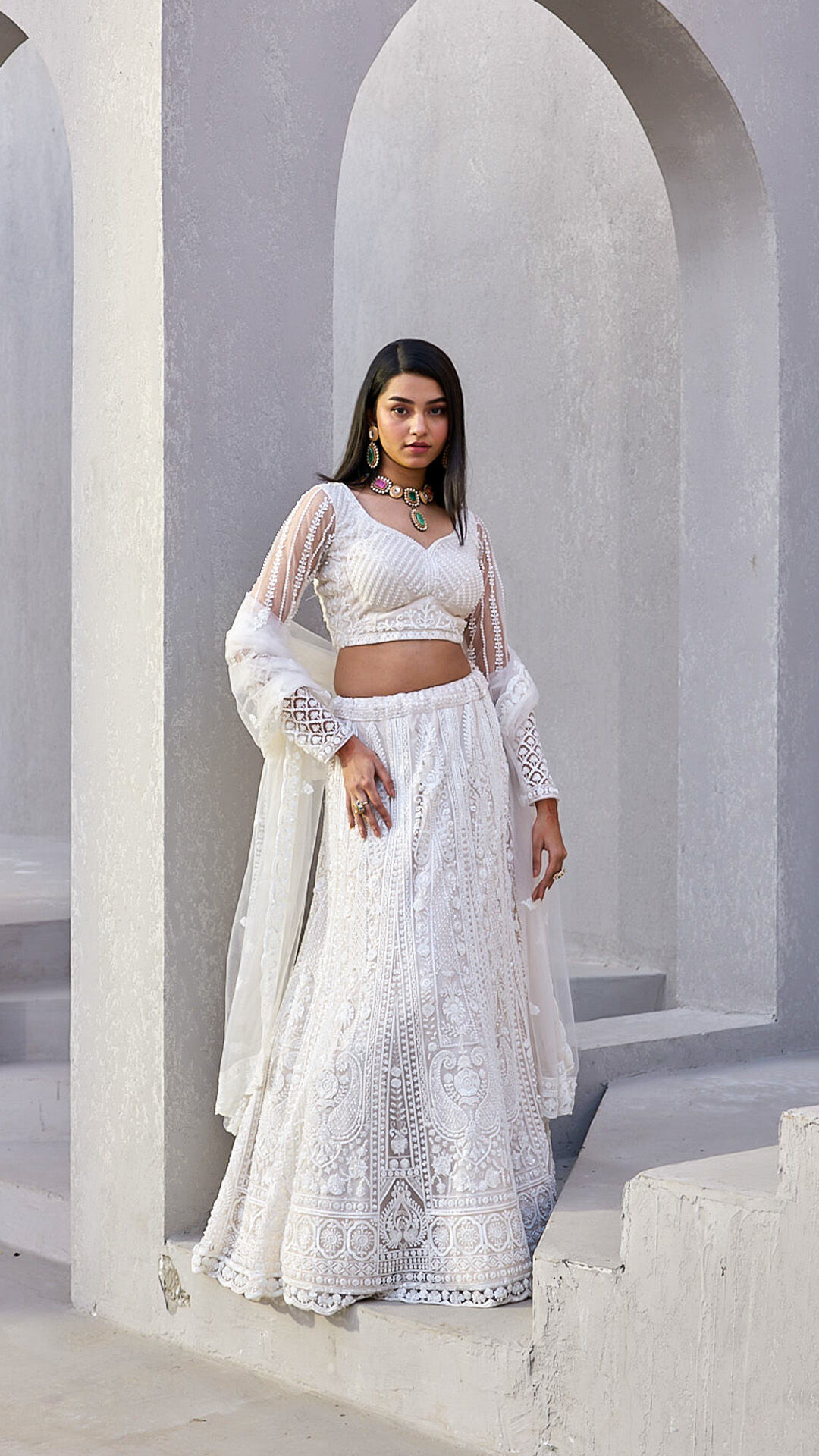 Woman flaunting a chic white modern lehenga with a matching white dupatta, a contemporary bridal fashion choice.